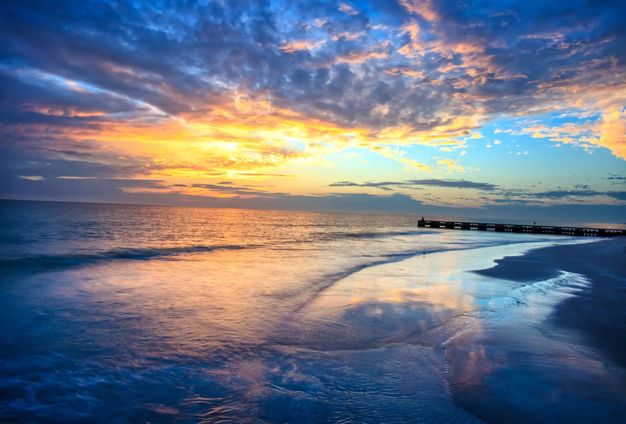 Sunset over a calm ocean with vibrant colors reflecting on the water.