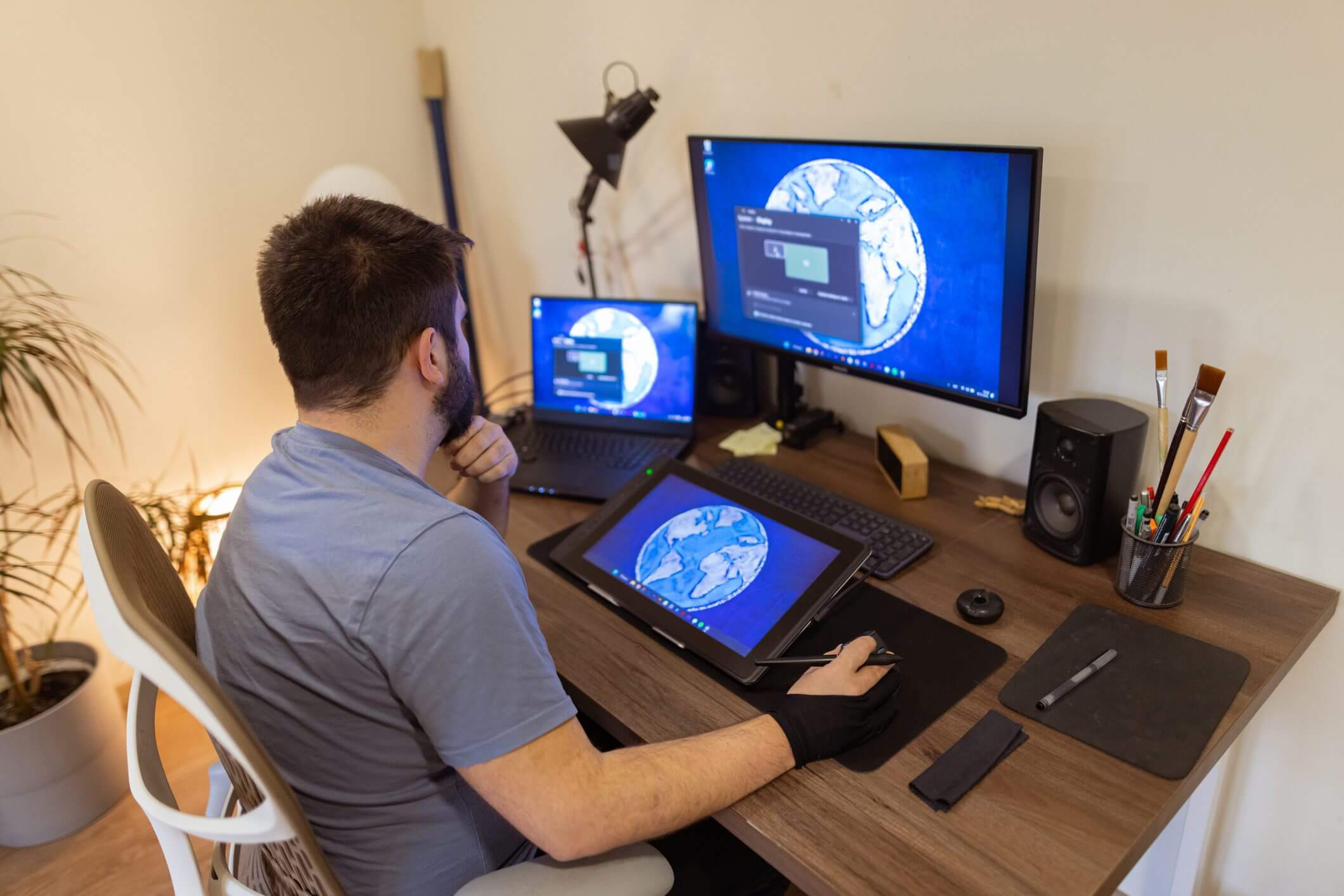 Person using digital drawing tablet connected to dual monitors.