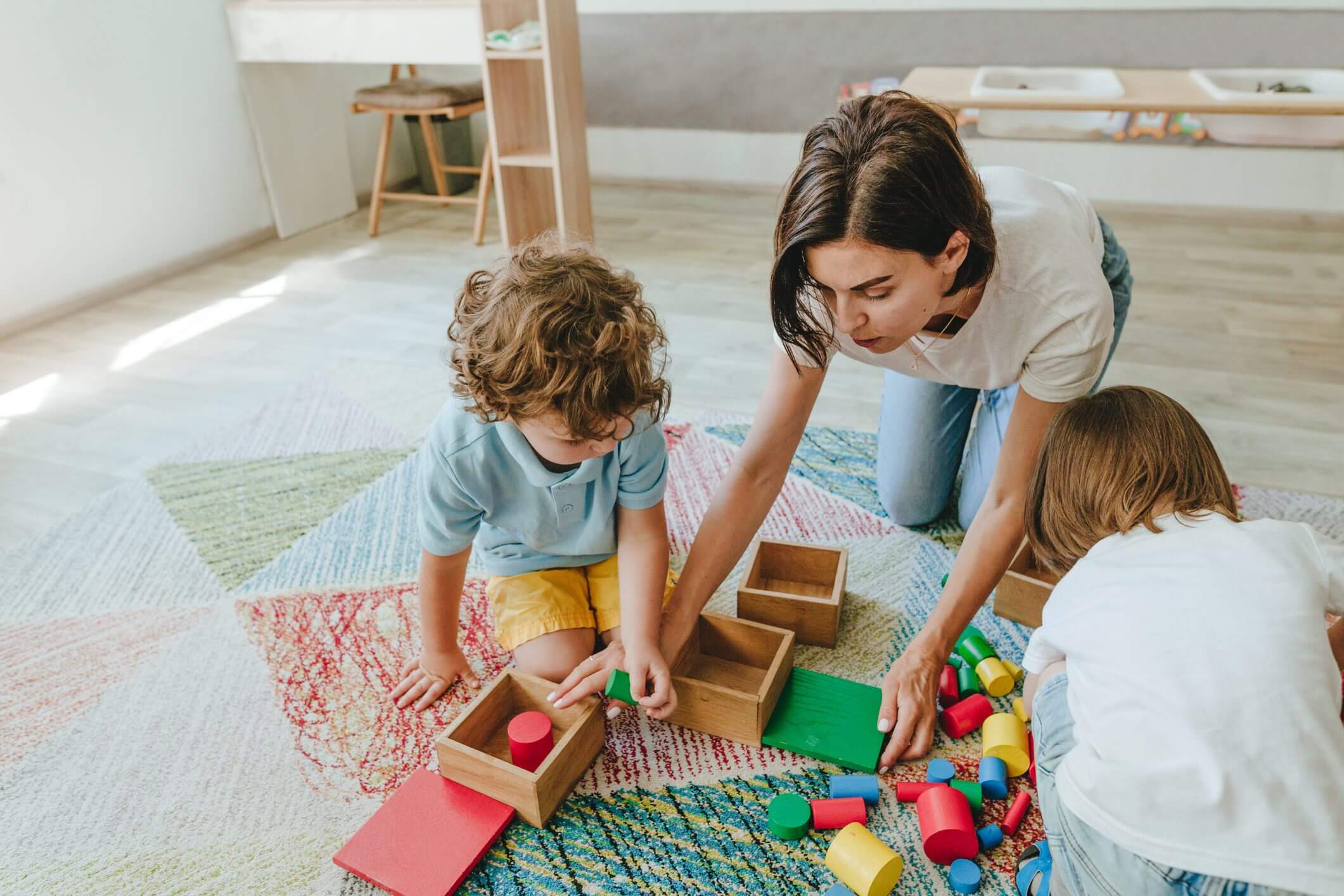 A mother and child playing with wooden blocks and toys.