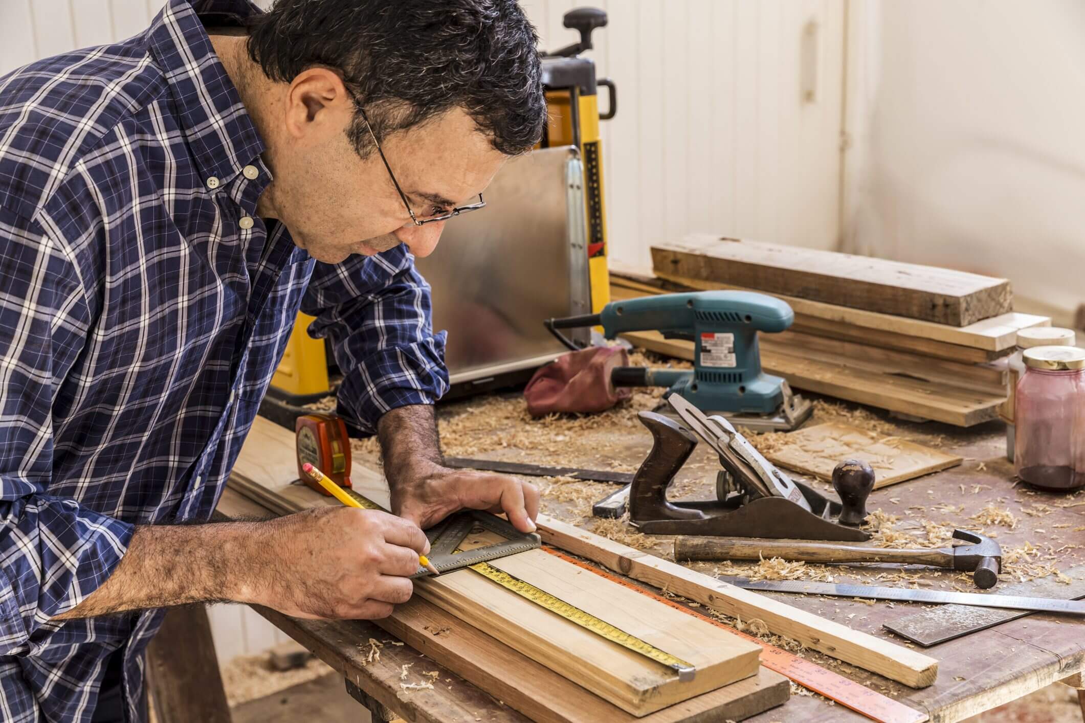 Man crafting wood pieces in a workshop.