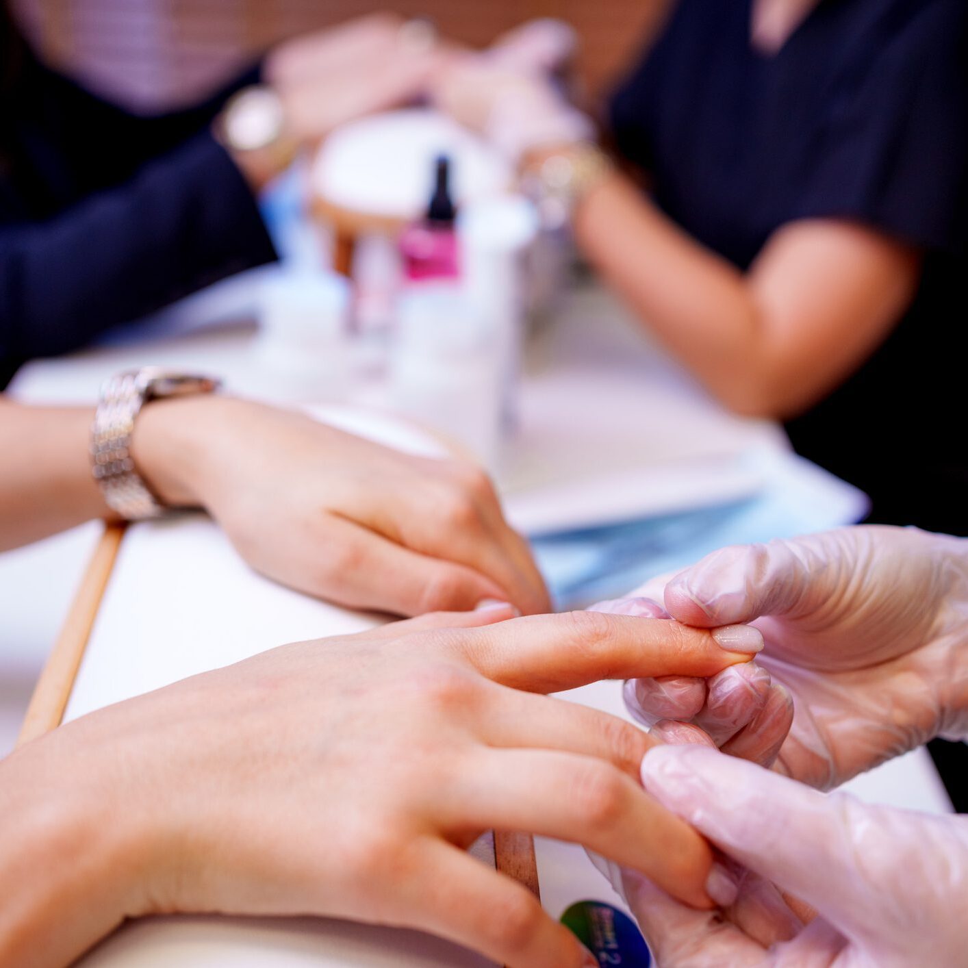 A person receiving a manicure at a nail salon.